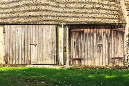 在英语农村有两扇门的旧木制谷仓图片