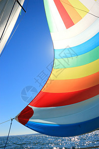 风把帆船上的脊柱装满了风向深蓝天空的彩色航行详情图片