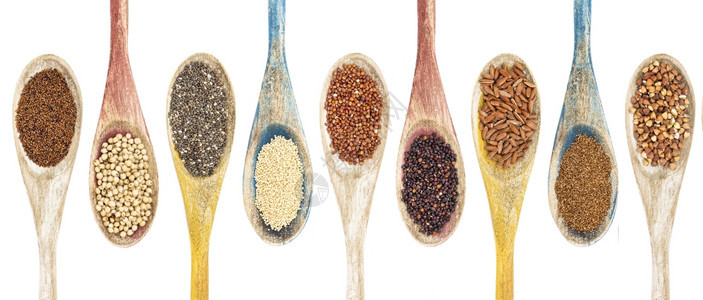 在孤立的木勺上从左到右收集了免费的谷粒和种子这些木勺是kaniwa高梁chiaamaranthredquinoa黑色quinoa图片