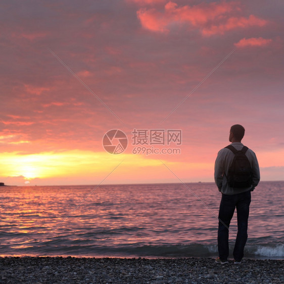 独自一个人看着海滩上的日落图片