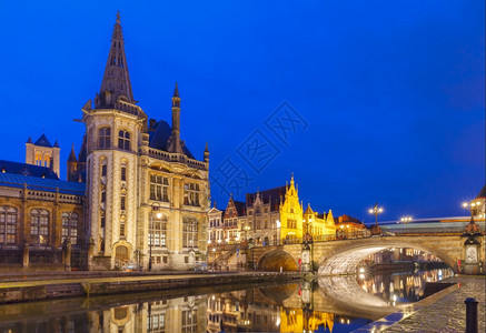 在比利时根特镇夜里莱河的QuayGrasleiQuayGraslei上拍摄中世纪建筑和邮宫图片