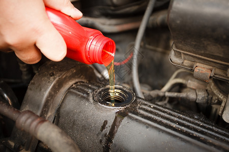 汽车维修工把油倒到发动机上关闭了被倒进汽车的新鲜油图片
