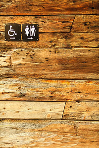 木壁背景上的公共厕所标志图片