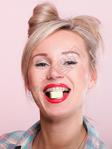 欢快的钉子女孩翻版风格肖像针女人吃巧克力粉红色背景图片