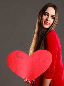 穿着红裙子的长发美女带着心爱的象征暗灰色背景图片