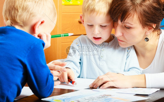 母亲帮助儿子一起做家庭作业图片