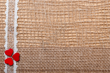 红色木制装饰式心胸带放在抽象布上背景带有复制空间图片