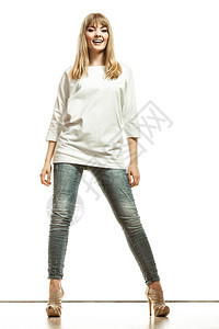 时装年轻金发年轻女子牛仔裤白蝙蝠袖高跟鞋完全孤立的女模特图片