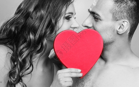 有吸引力的年轻夫妇在红心后亲吻黑人白照片图片