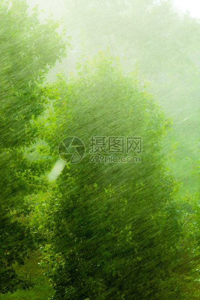 在窗外的夏季雨中水滴在玻璃窗上作为背景纹理图片