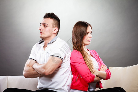 男人和女意见不一争吵后的年轻情侣坐在沙发上背对背景