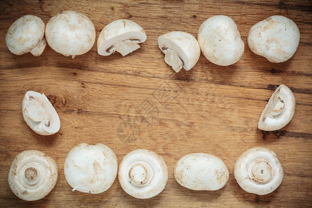 蔬菜食品新鲜白色蘑菇框架木制厨房餐桌背景的冠军图片