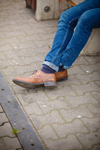 秋季时装脚穿鞋露在外面街上穿牛仔裤和靴子脱袜的男腿图片