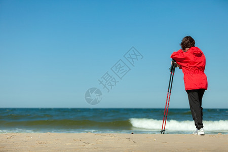 北欧人散步女在海滩上徒步旅行积极健康的生活方式图片