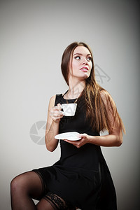 穿着丝袜的感年轻女孩拿着咖啡喝灰色图片