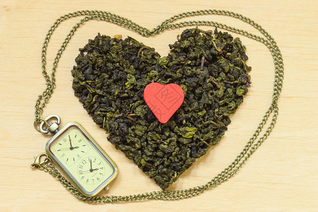 茶叶时间概念木表面形成的绿茶心降低脏病风险的健康食品饮料图片