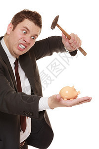 神经古怪的生意人拿着锤子准备砸在白边孤立的小猪银行图片