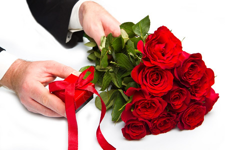 manrrsquuo手与红玫瑰花束和礼品盒图片