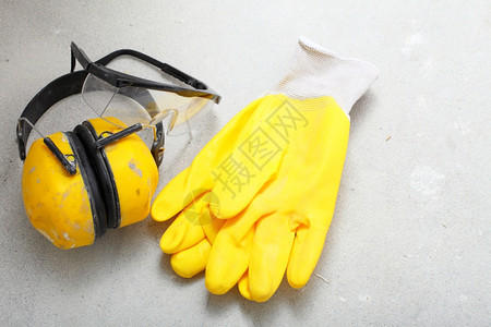 建筑设备工具在地使用黄色保护噪音手套图片