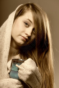一位美丽的caucasian女人的近身拿着一杯蓝色的热饮图片