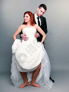 喜笑快乐的已婚夫妇肖像红发新娘和郎全长工作室的红发新娘和郎拍摄在灰色背景上图片