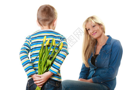 假日母亲概念后视小男孩背着一堆黄色的郁金香准备给母亲一个惊喜图片