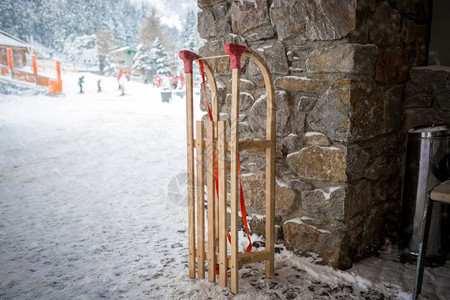 石墙旁边街上古老的木雪橇近照片图片