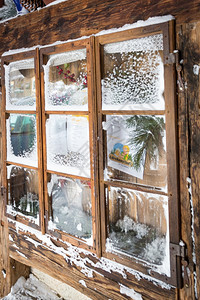 雪覆盖木框的旧窗口近照片图片