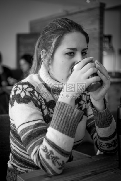 在咖啡馆喝着的毛衣中年轻女子黑白画像图片