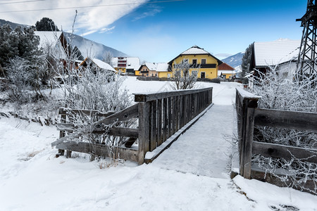 雪天阿尔卑斯山河上旧小木桥图片