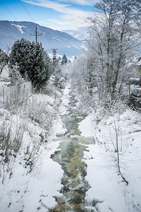 积雪覆盖的森林中快速山流美丽景观图片