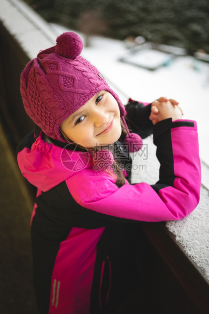 长着可爱的笑女孩肖像在寒冬日雪的街上摆布图片