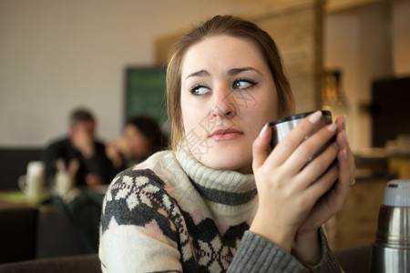 穿着毛衣在咖啡馆喝的悲哀女人近贴肖像图片
