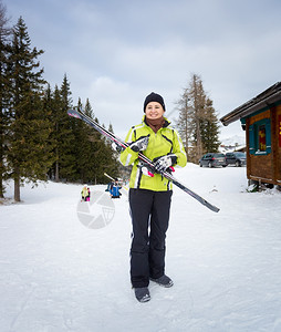 美丽的微笑着女士装滑雪在斜坡上图片