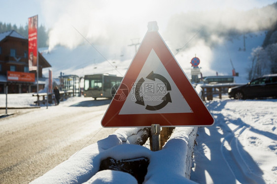 山上雪覆盖的公路上警示标志的紧贴照片图片