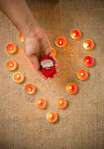 将金环绑在盒子里的人与蜡烛制作的心脏对立概念照片图片