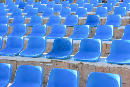 阳光照耀的蓝椅子体育场图片