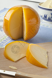 整片黄色圆环爱达姆奶酪切片在割板上图片