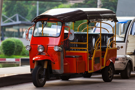 在泰国街头的红色旅游出租三轮摩托车图片