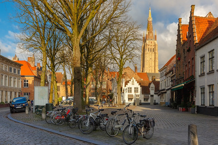 在美丽的中世纪城市布鲁格Brugge的华府广场上在比利时的清晨在前方是停车自行在圣母会的背景教堂图片