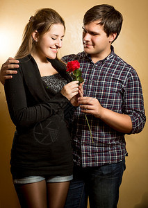 将红玫瑰献给可爱女友的笑男人片场肖像图片