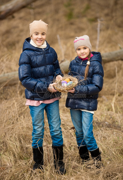 两名小孩拿着篮子里的彩蛋的肖像图片