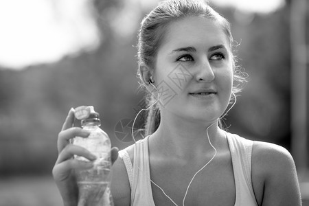 在公园里喝瓶水给感运动女的黑白近身画像图片