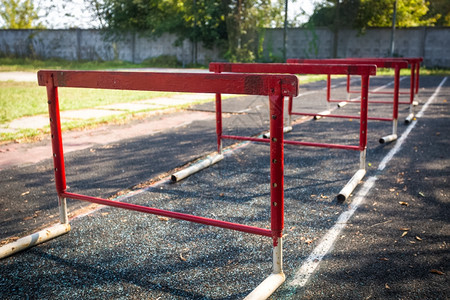 在废弃体育场进行障碍赛的一排旧红色障碍图片