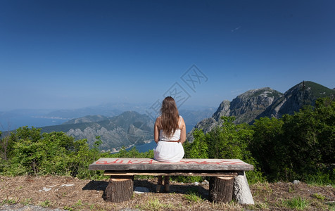 坐在高山长椅上的美丽黑发女图片