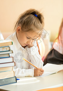 学校教科书中悲伤女孩写作练习的特肖像图片