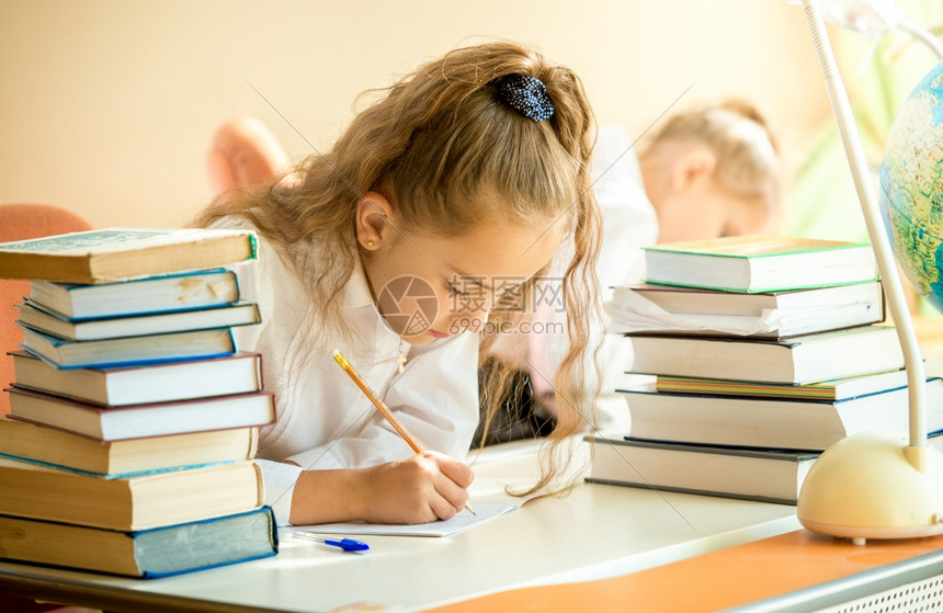 集中的女学生肖像周围都是做功课的书本图片