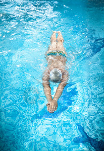 戴护目镜的年轻人在游泳池水下背景图片