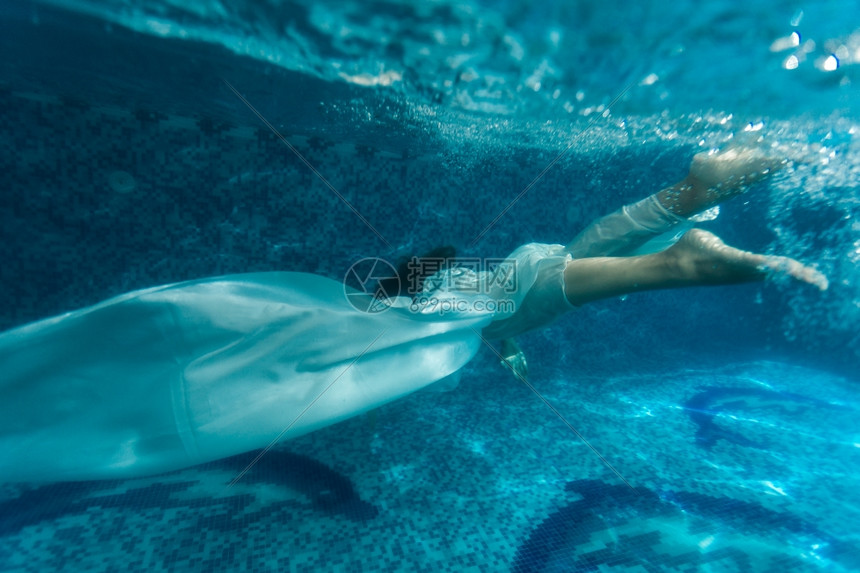 穿白织物在游泳池中潜水的美女下镜头图片