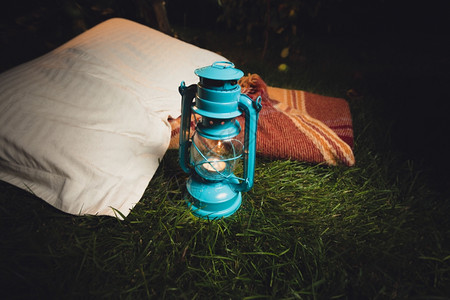 夜里躺在草地上的旧灯笼枕头和毯子的近照图片